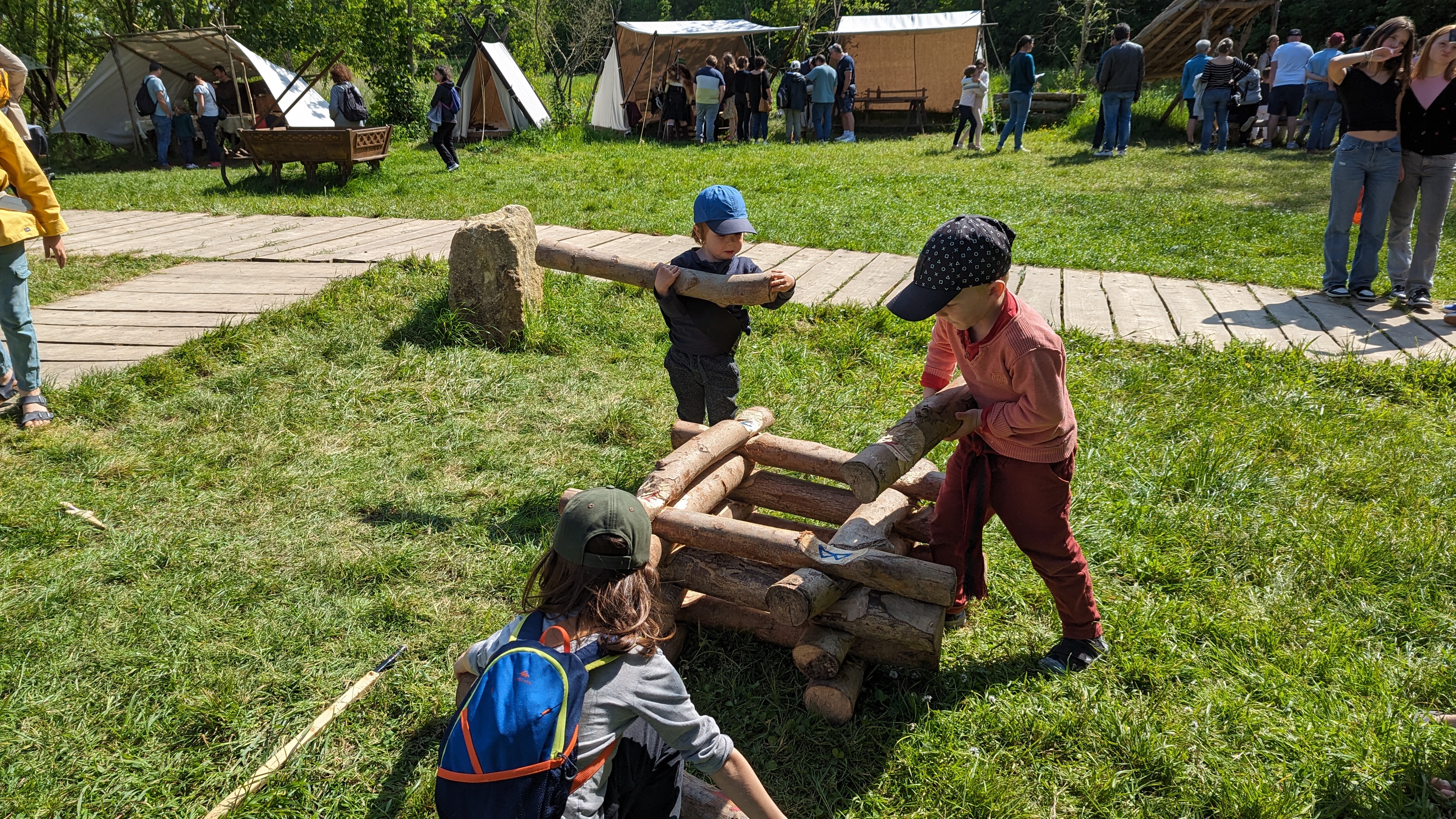 enfants en train de construire une structure en bois à l'occasion de la fête des Bâtisseurs.